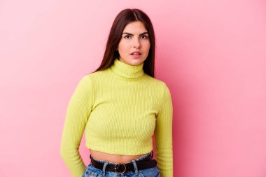 Pembe arka planda soyutlanmış beyaz bir kadın üzgün, ciddi bir yüz, mutsuz ve hoşnutsuz..