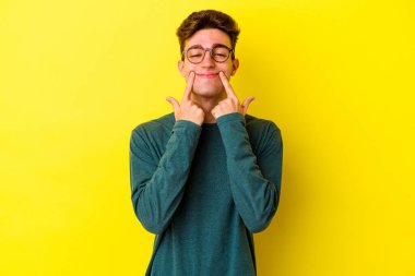 Kafkasyalı genç, sarı arka planda izole edilmiş, iki seçenek arasında şüphe duyuyor..