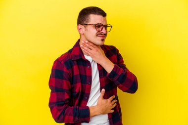 Sarı arka planda izole edilmiş beyaz bir adam virüs ya da enfeksiyon yüzünden boğazında ağrı hissediyor..