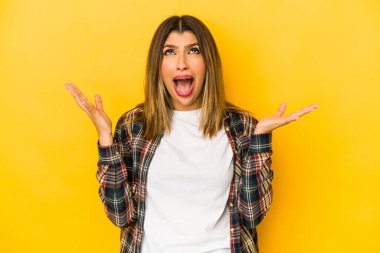 Sarı arka planda izole edilmiş genç Hintli kadın gökyüzüne haykırıyor, yukarı bakıyor, hayal kırıklığına uğramış..