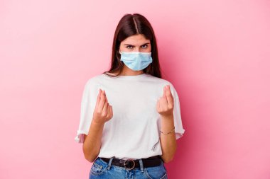Virüs maskesi takan beyaz bir kadın. Pembe arka planda izole edilmiş. Parası olmadığını gösteriyor..