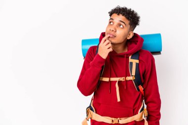 Genç Afro-Amerikan Kıvırcık Adam izole edilmiş. Bir şeyin fotokopi alanına baktığını düşünüyor..