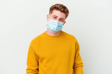 Koronavirüs maskesi takan genç adam beyaz arka planda izole edilmiş mutlu, güler yüzlü ve neşeli..