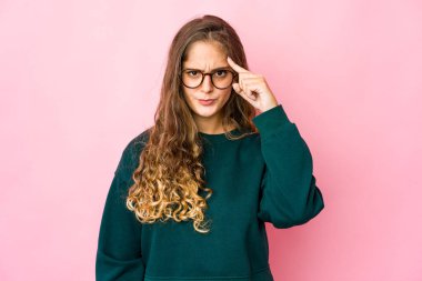 Kafkasyalı genç bir kadın şakağı parmağıyla işaret ediyor, düşünüyor, bir göreve odaklanıyor..