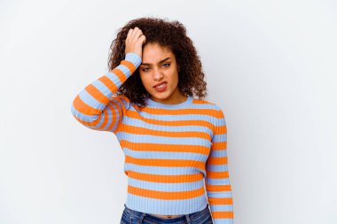 Beyaz arka planda izole edilmiş genç Afrikalı Amerikalı kadın bir şeyi unutuyor. Alnına avuç içi ve kapalı gözlerle tokat atıyor..