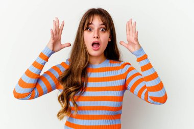 Beyaz arka planda izole edilmiş beyaz bir beyaz kadın zaferi ya da başarıyı kutluyor, şaşırıyor ve şok oluyor..