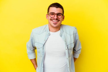 Sarı arka planda izole edilmiş genç beyaz adam mutlu, güler yüzlü ve neşeli..