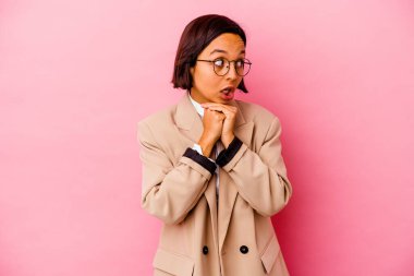 Pembe arka planda izole edilmiş genç iş kadını şans diliyor, şaşırıyor ve ağzını açıyor..