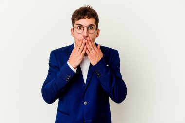 Beyaz arka planda izole edilmiş genç beyaz bir adam elleriyle ağzını kapatırken şok oldu..