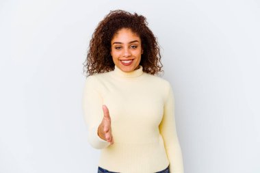 Beyaz arka planda izole edilmiş genç Afrikalı Amerikalı kadın selamlaşma jesti olarak kameraya uzanıyor..