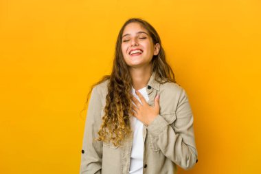 Genç beyaz kadın elini göğsüne koyup kahkahalarla gülüyor..