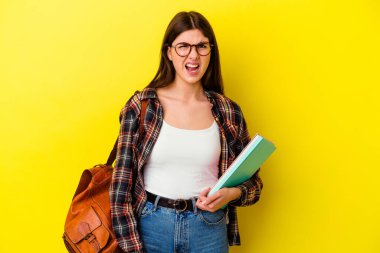 Sarı arka planda izole edilmiş genç bir bayan çok sinirli ve agresif çığlıklar atıyor..