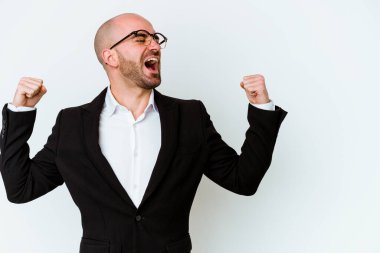 Beyaz arka planda izole olmuş beyaz saçlı genç bir beyaz adam zaferden sonra yumruğunu kaldırıyor, kazanan konsept..