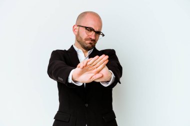 Genç, beyaz, kel bir adam, mavi arka planda izole edilmiş, elini uzatmış, dur işareti göstererek, seni engelliyor..