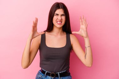 Pembe arka planda izole edilmiş beyaz bir kadın öfkeyle bağırıyor..