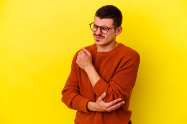 Sarı arka planda izole edilmiş, kafası karışmış, şüpheli ve güvensiz genç beyaz bir adam..