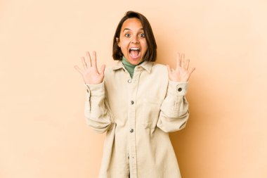 Latin kökenli genç bir kadın 10 numarayı elleriyle gösteriyor..