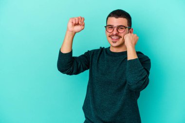 Genç beyaz adam mavi arka planda izole edilmiş dans ediyor ve eğleniyor..