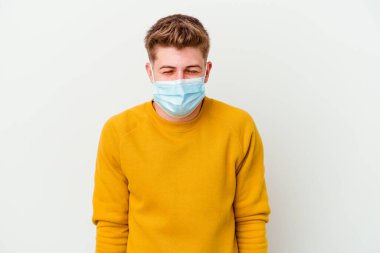 Koronavirüs maskesi takan genç bir adam beyaz arka planda izole edilmiş, güler ve gözlerini kapatır, rahat ve mutlu hisseder..