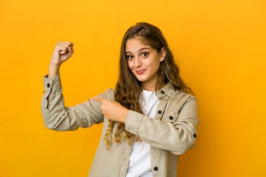 Kafkasyalı genç bir kadın güç sembolü olan kollarıyla güç gösterisi yapıyor.