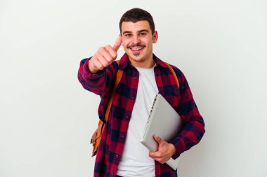 Beyaz arka planda dizüstü bilgisayar tutan beyaz tenli genç bir öğrenci. Baş parmakları havada, bir konuda tezahürat yapıyor, destek ve saygı duyuyor..