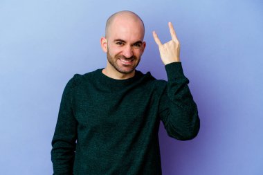 Mor arka planda izole edilmiş beyaz, kel bir adam parmaklarıyla taş hareketi gösteriyor.