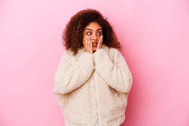 Genç Afrikalı Amerikalı kadın pembe arka planda izole edilmiş korkmuş ve korkmuş..