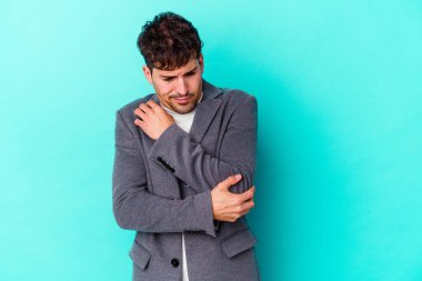 Kafkasyalı genç adam mavi arka planda izole, kafası karışmış, şüpheli ve güvensiz hissediyor..