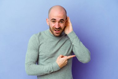 Mor arka planda izole edilmiş beyaz kel bir adam bir dedikoduyu dinlemeye çalışıyor..