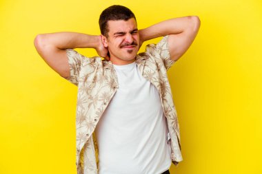 Kafkas asıllı genç adam sarı arka planda izole edilmiş sabit yaşam tarzından dolayı boyun ağrısı çekiyor..