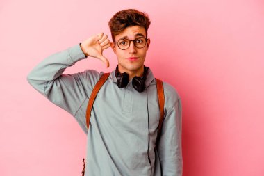 Pembe arka planda izole edilmiş genç bir öğrenci, hoş olmayan bir jest gösteriyor, kabul etmiyor. Anlaşmazlık konsepti.