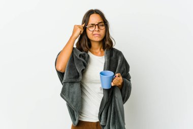 Beyaz arka planda battaniyeyle izole edilmiş genç Latin bir kadın bir göreve odaklanmış, parmaklarını işaret ediyor..