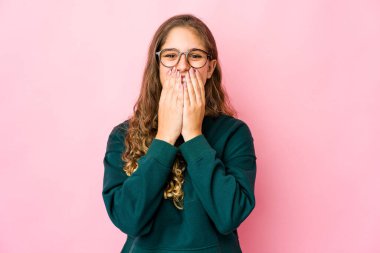 Kafkasyalı genç bir kadın bir şeye gülüyor, elleriyle ağzını kapatıyor..