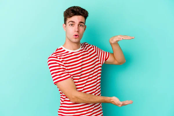 Young Caucasian Man Isolated Blue Background Holding Something Both Hands — Stock Photo, Image