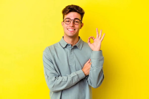 Joven Hombre Caucásico Aislado Sobre Fondo Amarillo Guiña Ojo Sostiene — Foto de Stock