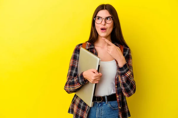 Joven Estudiante Caucásica Sosteniendo Portátil Aislado Sobre Fondo Rosa Apuntando — Foto de Stock