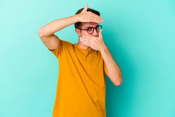 Young Caucasian Man Isolated Blue Background Blink Camera Fingers Embarrassed — Stock Photo, Image