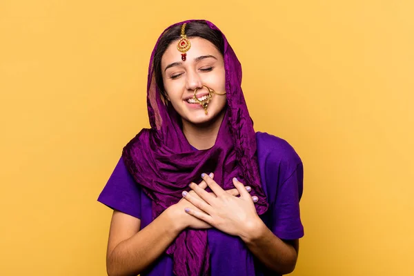 黄色の背景に孤立した伝統的なサリーを身に着けている若いインドの女性は 心に手を取り合って笑って 幸福の概念 — ストック写真