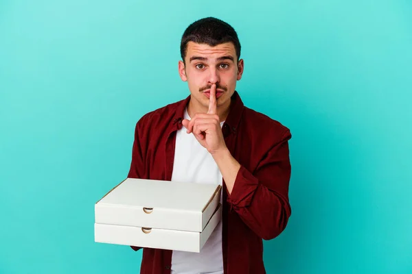 Young Caucasian Man Holding Pizzas Isolated Blue Background Keeping Secret — Stock Photo, Image