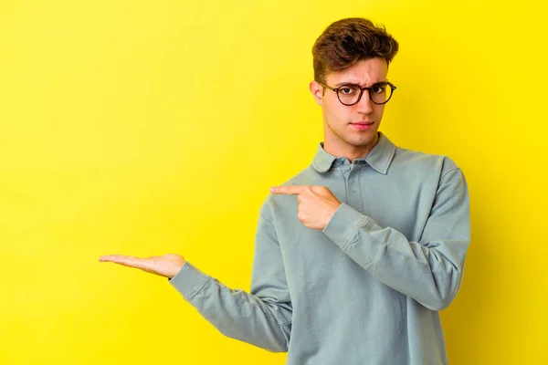 Junge Kaukasische Mann Isoliert Auf Gelbem Hintergrund Aufgeregt Hält Eine — Stockfoto