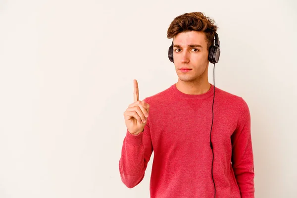 Jovem Caucasiano Ouvindo Música Isolada Fundo Branco Mostrando Número Com — Fotografia de Stock