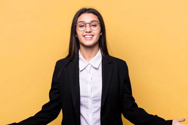 Stock image Young Indian business woman isolated on yellow background showing a welcome expression.