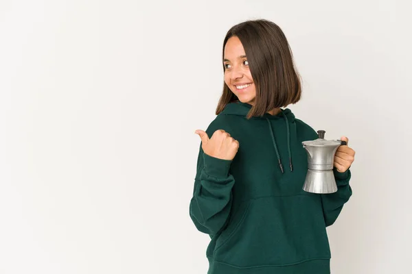 Mujer Hispana Joven Sosteniendo Una Cafetera Señala Con Dedo Pulgar —  Fotos de Stock