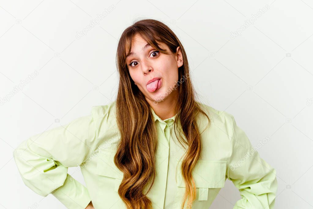 Young caucasian cute woman isolated on white background funny and friendly sticking out tongue.
