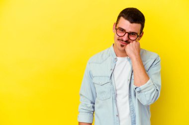 Sarı arka planda izole edilmiş, üzgün ve dalgın hisseden, kopyalama alanına bakan beyaz bir adam..