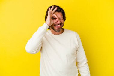 Orta yaşlı, beyaz bir adam sarı arka planda izole edilmiş. Heyecanlı..