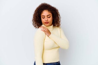 Beyaz arka planda, omuz ağrısı çeken genç bir Afrikalı Amerikalı kadın..