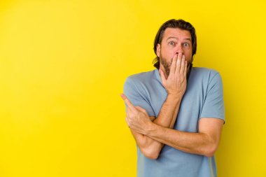 Sarı arka planda izole edilmiş orta yaşlı beyaz bir adam.