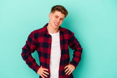 Mavi arka planda izole edilmiş genç beyaz adam mutlu, güler yüzlü ve neşeli.