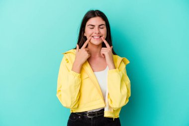 Kafkasyalı genç bir kadın mavi arka planda izole edilmiş. İki seçenek arasında şüpheli..